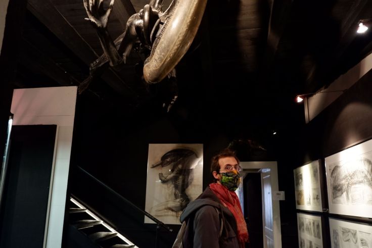 Ryan dans le musée H.R. Giger avec un alien au-dessus de lui