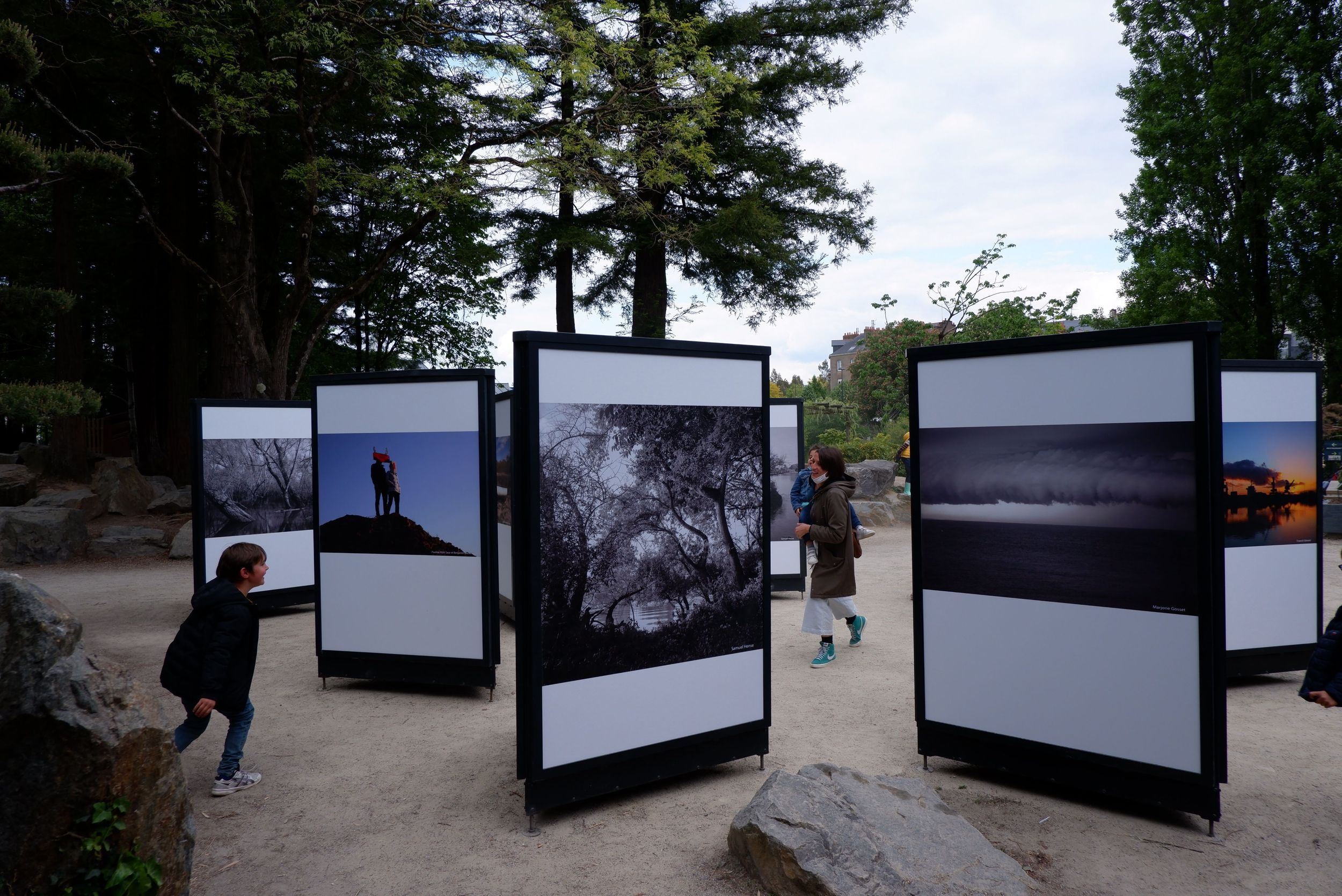 Des panneaux d'exposition sur l'île de Versailles et des gens qui jouent à chat entre les panneaux.