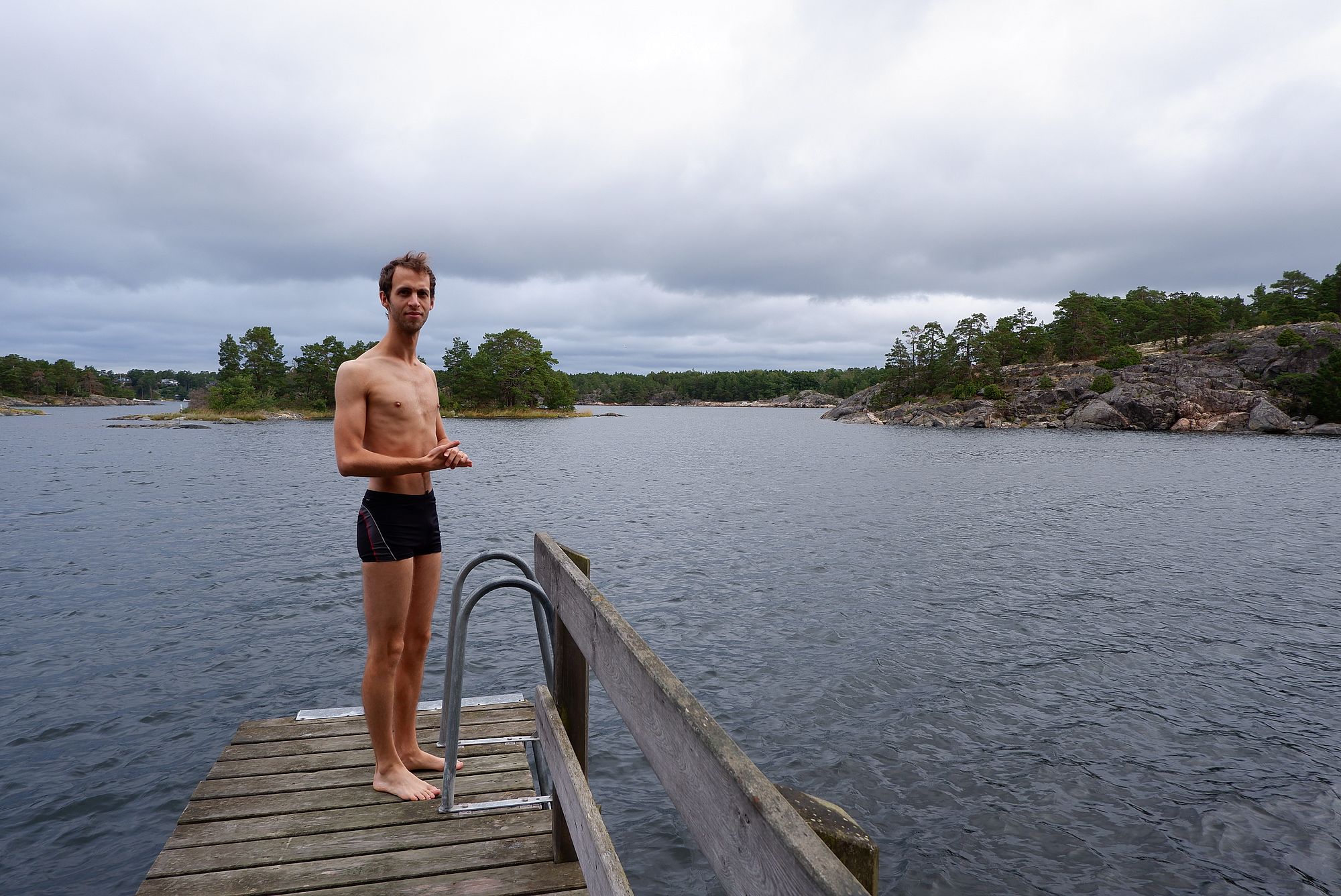 Ryan en maillot de bain sur un ponton au bord de l'eau