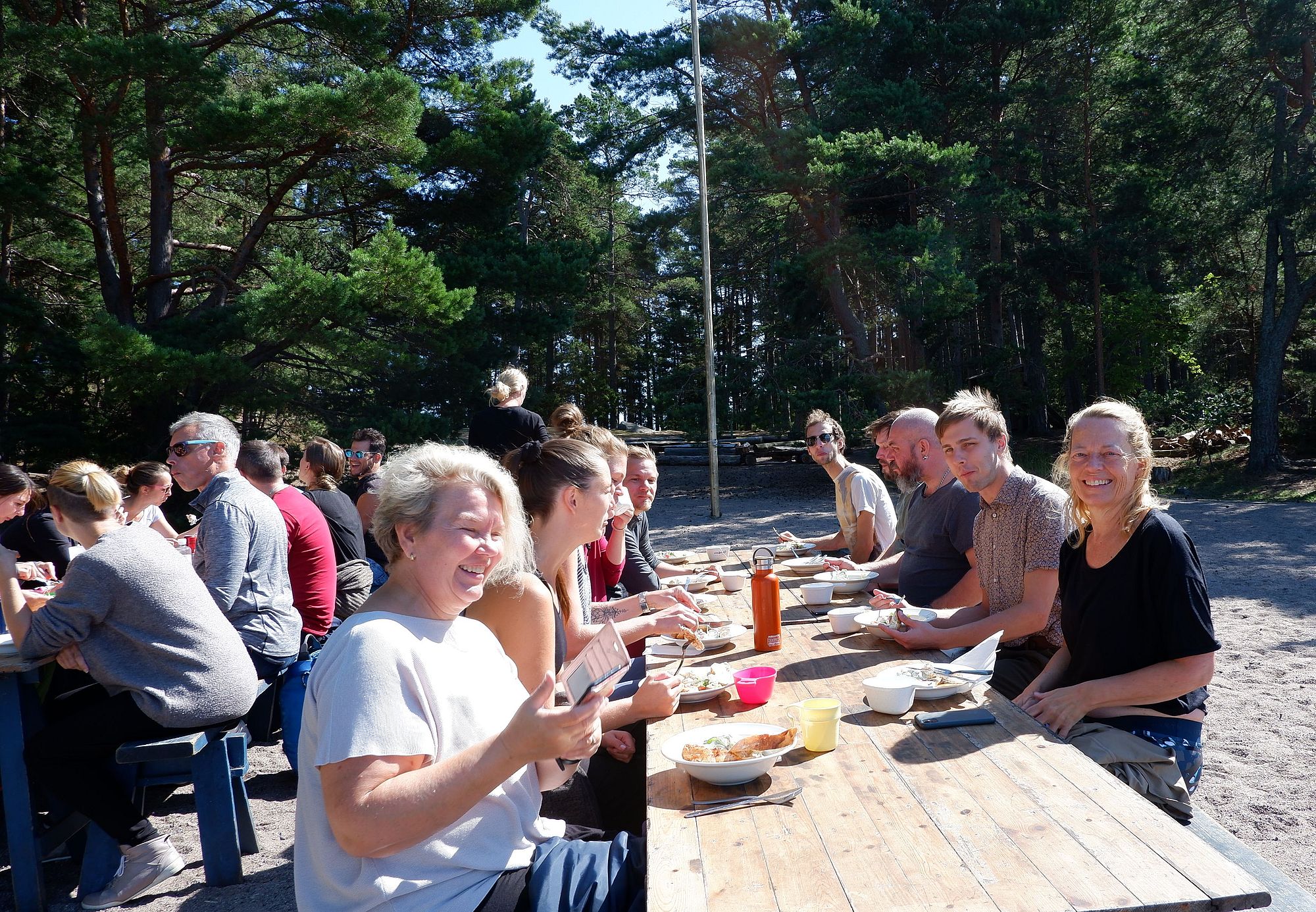 Tous les danseurs réunis à table sur la plage, sous le soleil
